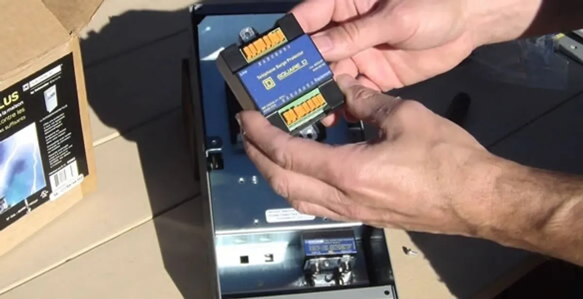 Electrician installing whole home surge protection unit inside main electrical panel in San Diego, CA