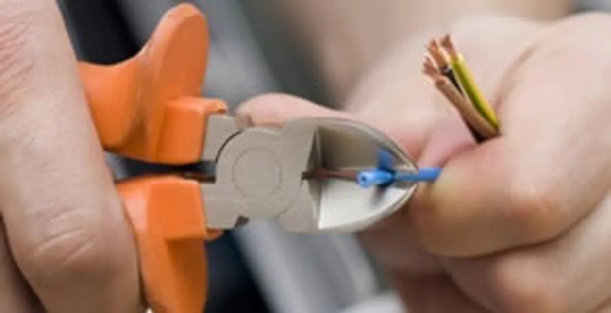 licensed electrician performing precise wire cutting and preparation during electrical service in San Diego, CA