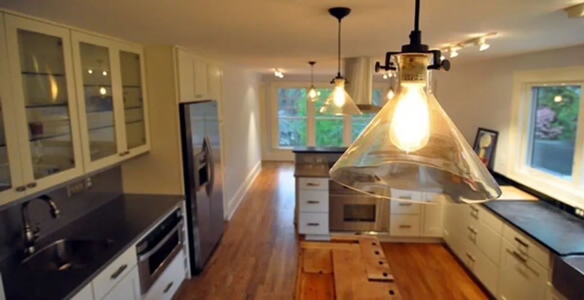 Residential electrician installing modern indoor light fixture in a home in San Diego, CA